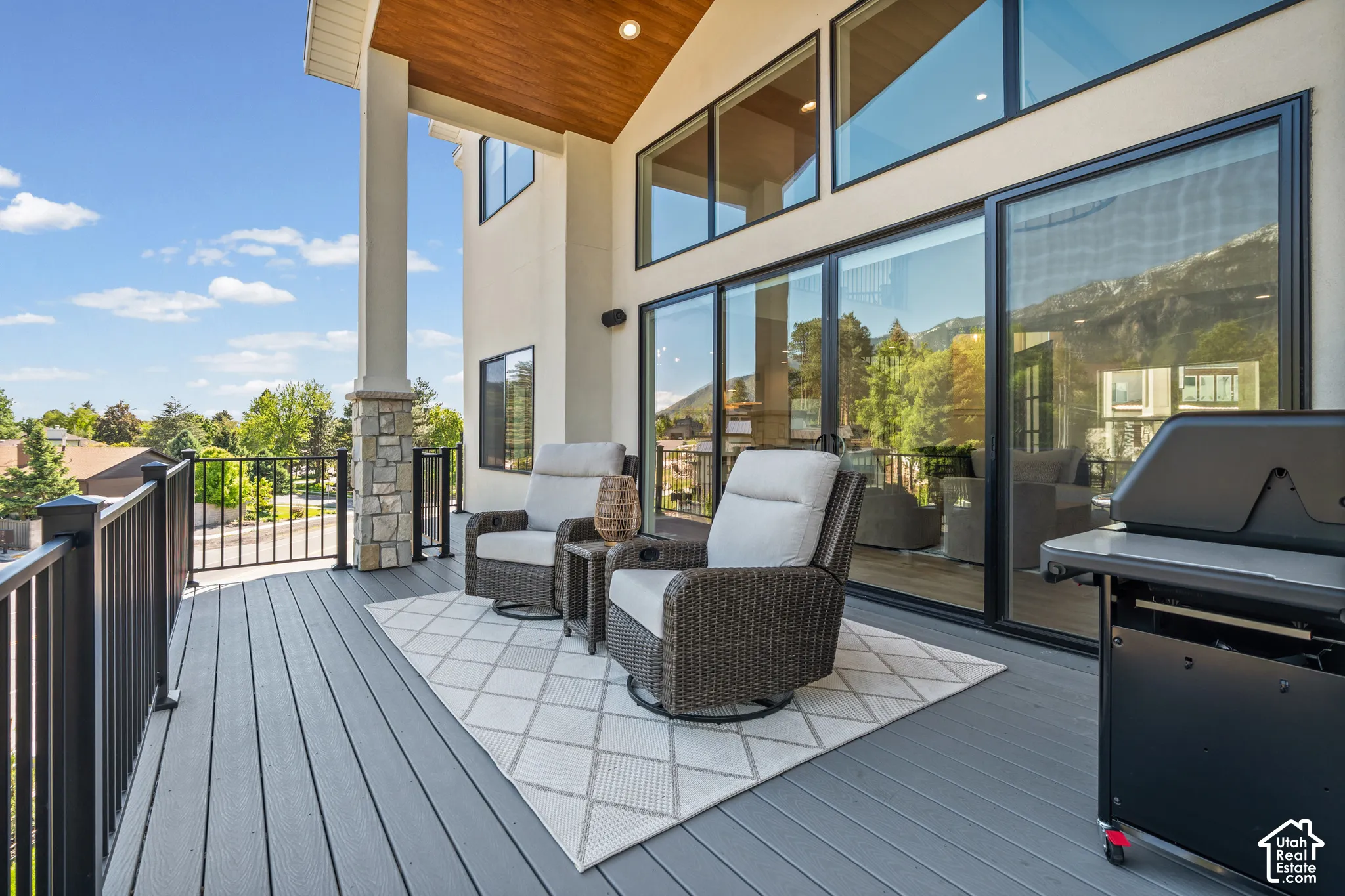 Spacious outdoor deck featuring gray composite decking and black metal railings