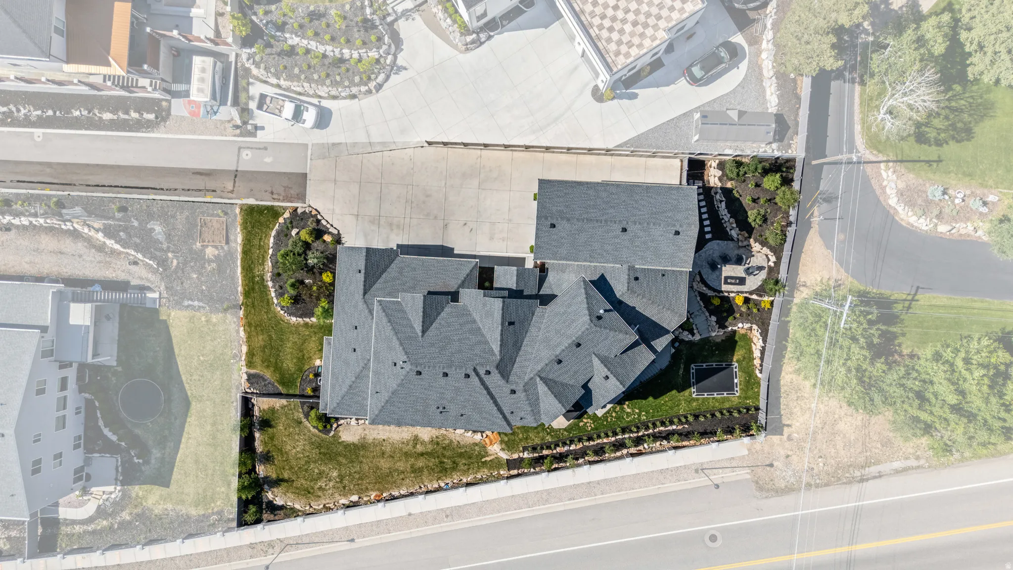 Aerial view showcasing a multistory residence with an intricate dark shingle roof
