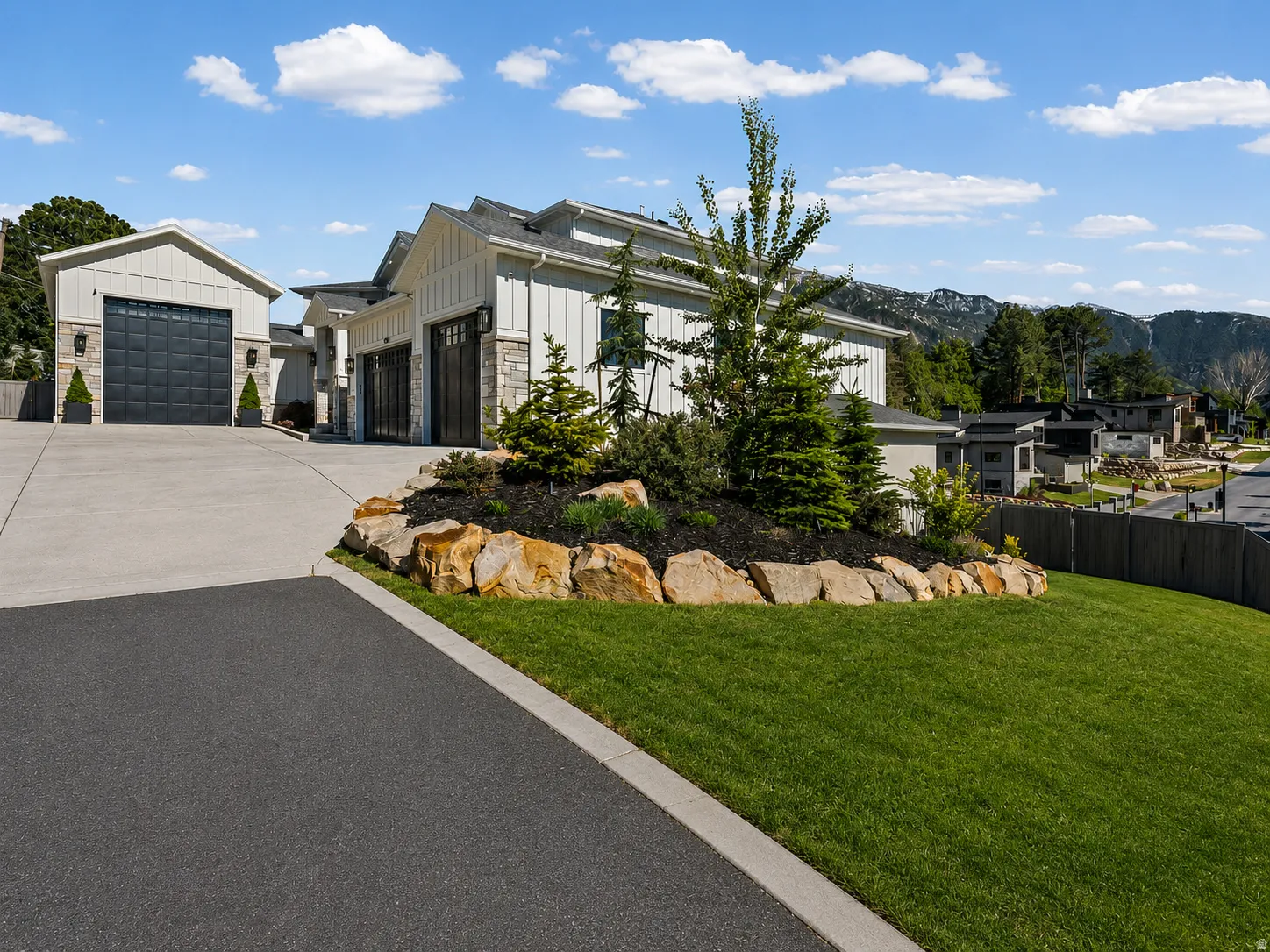 Modern home exterior featuring vertical white siding and stone accents