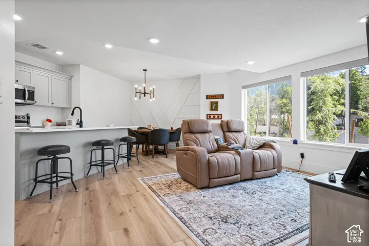Open-concept living space featuring wood-finish flooring, recessed lighting, and large windows