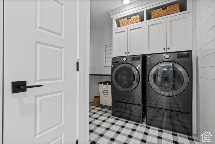 Laundry room featuring a patterned floor, white shaker-style cabinetry, and shiplap wall paneling