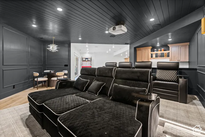 Dedicated media room featuring a dark shiplap ceiling, recessed lighting, and wall paneling