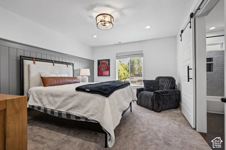 Spacious bedroom featuring board and batten accent wall, recessed lighting, and a modern ceiling fixture