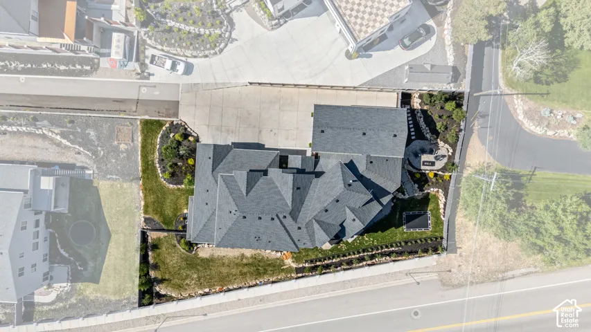 Aerial view showcasing a multistory residence with an intricate dark shingle roof