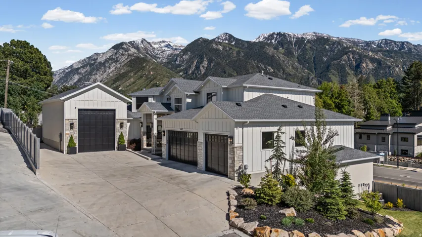 Modern multi-level exterior with vertical white siding and stone accents