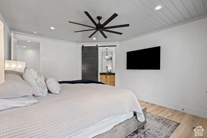 Bedroom featuring wood-finish flooring, a paneled ceiling with recessed lighting, a ceiling fan, and a wall-mounted television