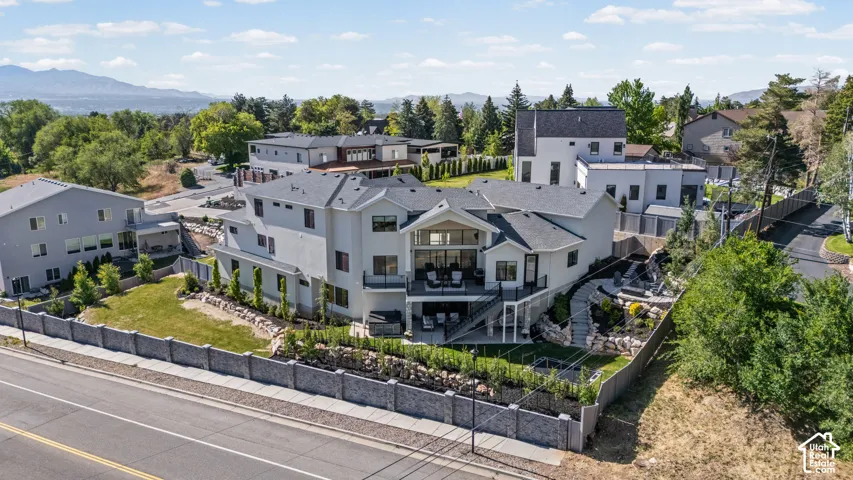 Contemporary multi-level residence featuring stucco exterior, multiple outdoor decks, and a terraced backyard with landscaping