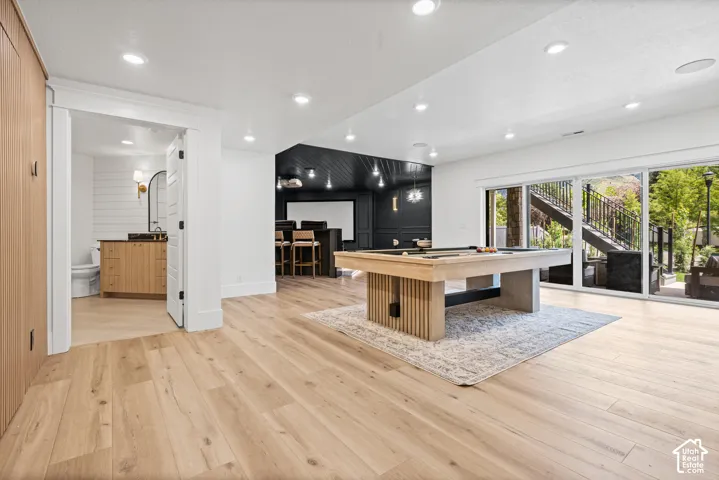 Expansive recreation room featuring wood-finish flooring, recessed lighting, and a billiards table