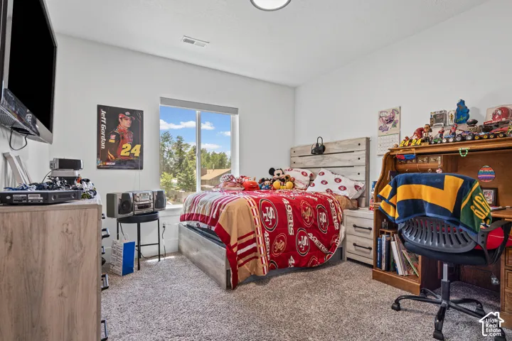 Bedroom featuring a large window, light gray carpet, and a white ceiling