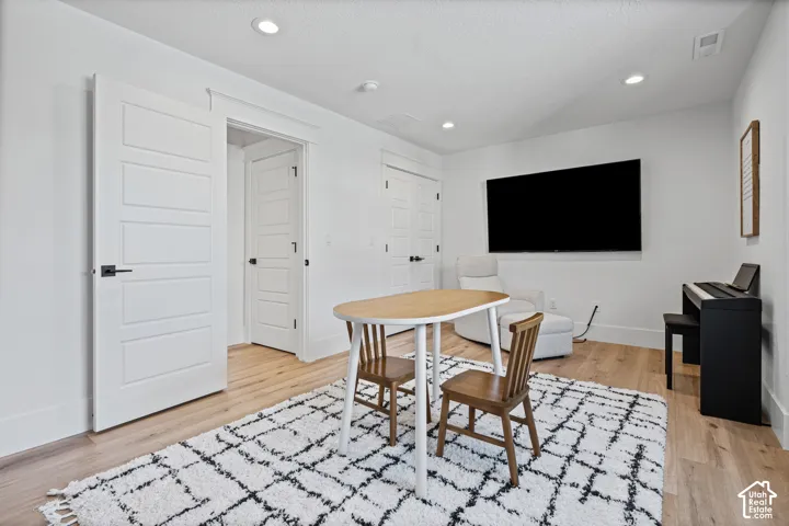 Bright room featuring wood-finish flooring, recessed lighting, and white baseboards