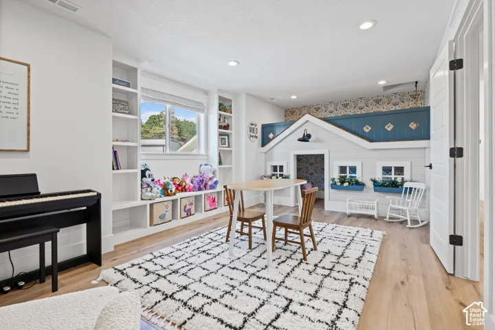 Spacious room featuring light wood-finish flooring, recessed lighting, and a built-in playhouse structure
