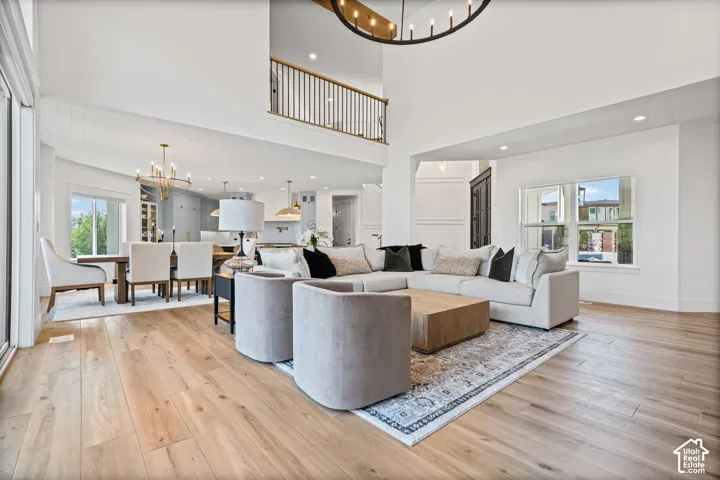 Great room with high ceilings, wood-finish flooring, and a large multi-pane window