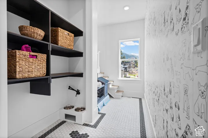 Custom built-in shelving with integrated pet feeding station and wall-mounted faucet