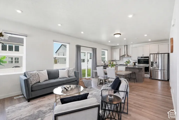 Open-concept living space featuring wood-finish flooring, recessed lighting, and white walls