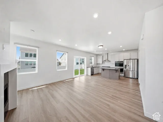 Open-concept living space featuring wood-finish flooring, recessed lighting, and a modern kitchen