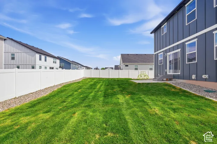 Expansive green lawn with a white privacy fence