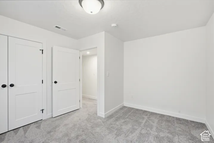 Room featuring neutral wall finishes, gray patterned carpeting, white trim, and a white ceiling light fixture