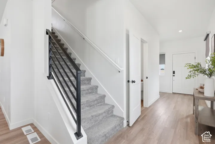 Modern staircase featuring black metal railings and grey carpeted treads