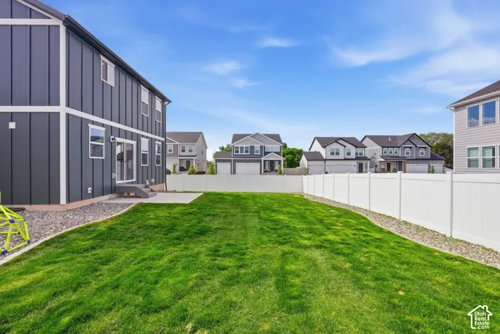 Spacious backyard featuring a manicured lawn, a concrete patio, and a privacy fence