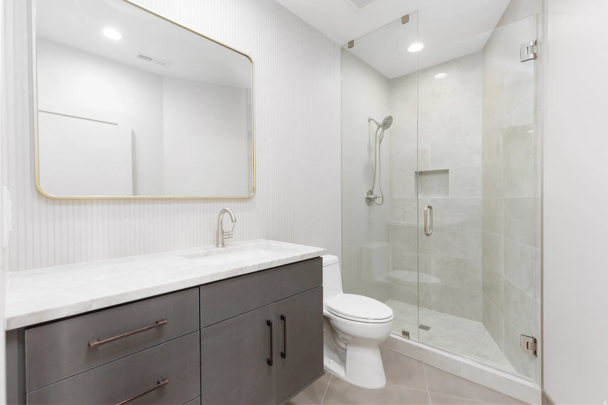 Guest bathroom #3 featuring a full glass shower, tiled backsplash and custom vanity.
