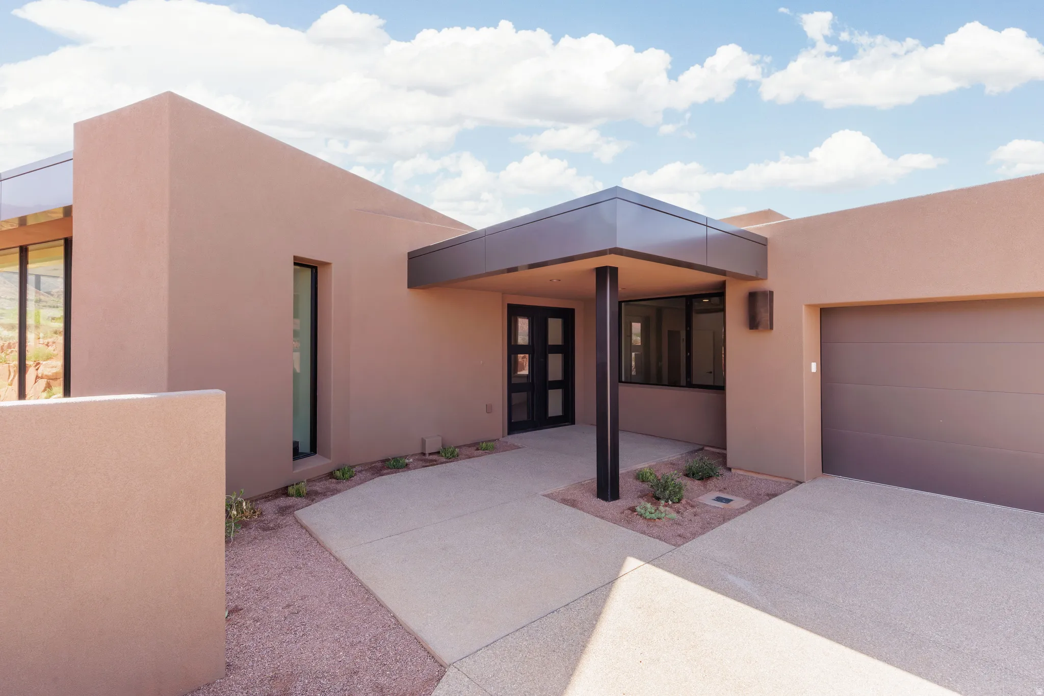 Exterior entryway featuring shaded covered patio and upgraded metal accent roof flashing.