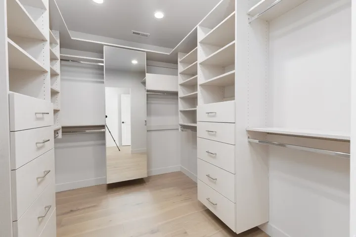 Primary closet with well planned custom drawers and shelving.