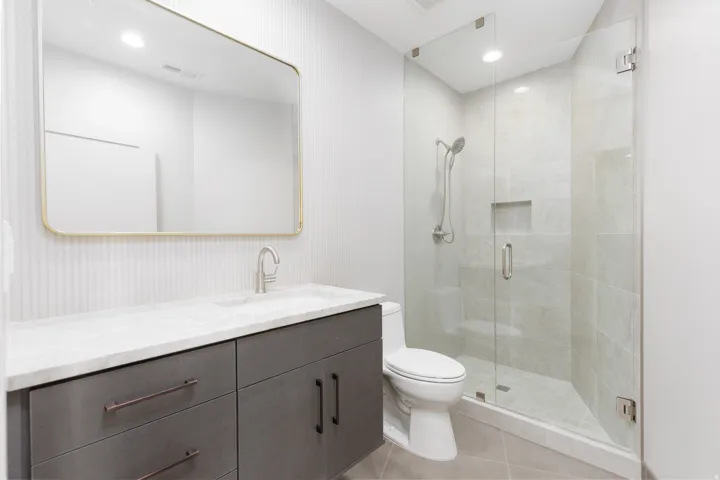 Guest bathroom #3 featuring a full glass shower, tiled backsplash and custom vanity.
