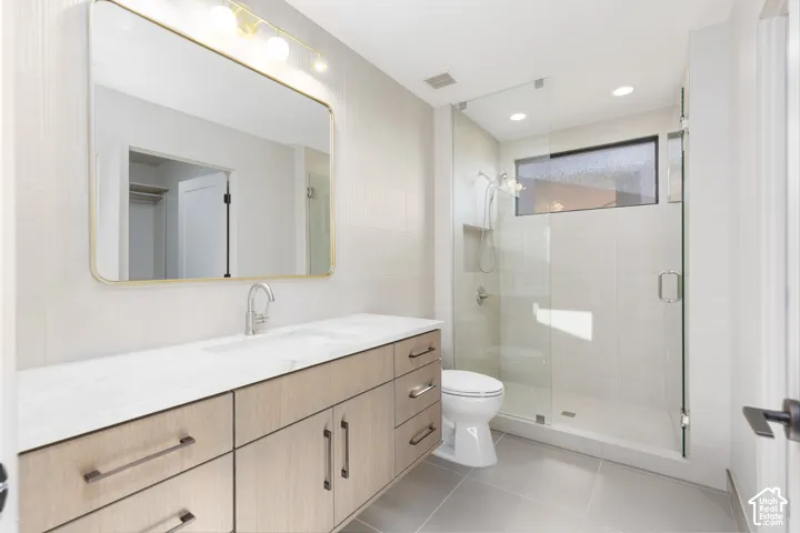 Guest ensuite #1 featuring a full glass shower, tiled backsplash and custom vanity.