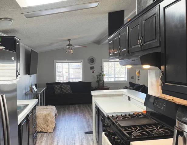 Kitchen featuring dark cabinetry, light countertops, and a gas range