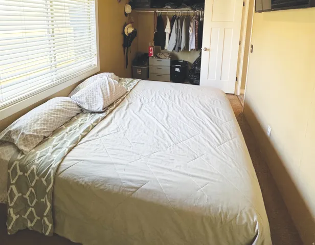 Bedroom featuring a window with horizontal blinds, carpeting, painted walls, and a built-in closet with a white paneled door