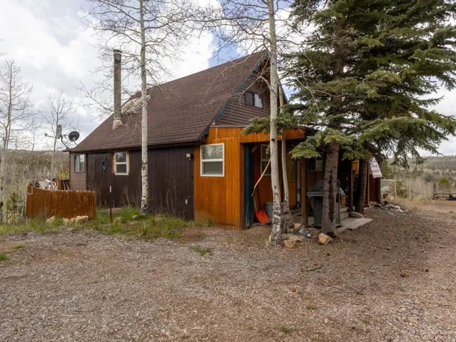 A-frame style property featuring a brown shingle roof and a combination of brown and wood-finish siding