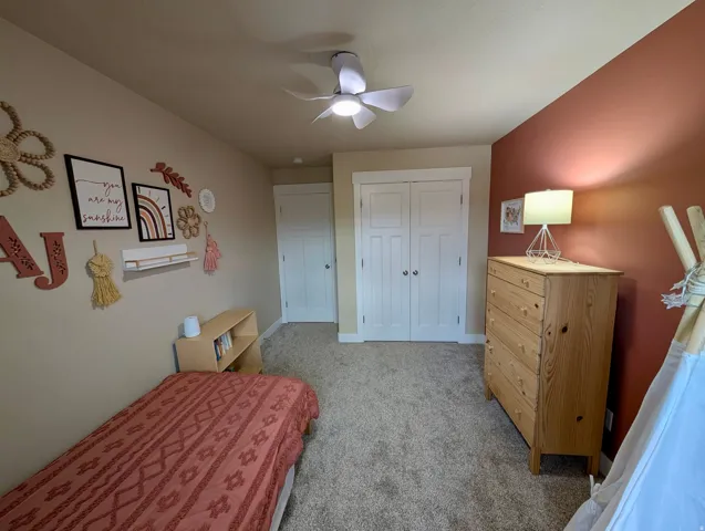 Wall-to-wall carpeting with light-colored walls and a distinct accent wall