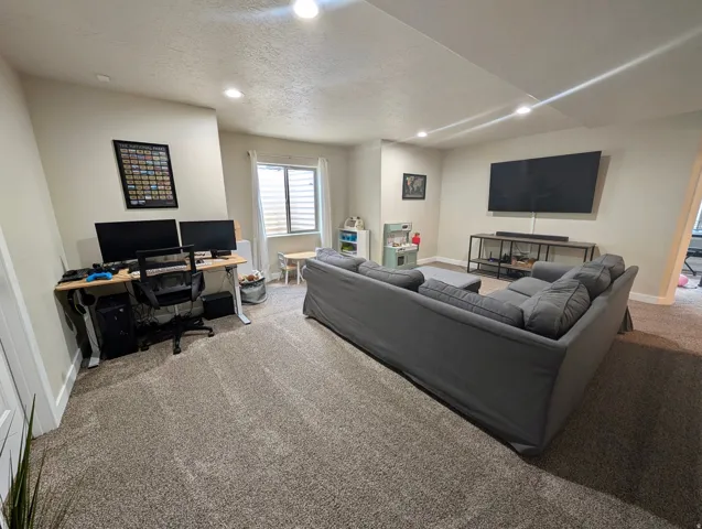 Spacious room with plush carpeting, recessed lighting, and light-toned walls
