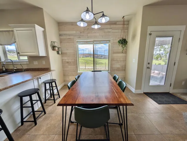 Open-concept dining area featuring a wood-finish plank accent wall