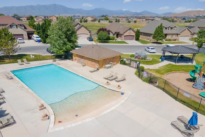 Outdoor swimming pool featuring a gradual entry, surrounding concrete patio, and chaise lounge seating