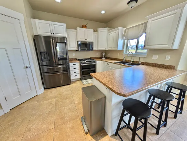 Modern kitchen featuring white cabinetry and stainless steel appliances