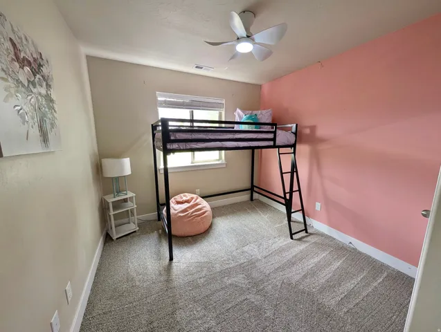 Room featuring light-toned carpeting and a prominent accent wall