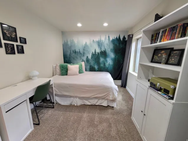 Recessed lighting illuminates neutral carpeting and light-toned walls