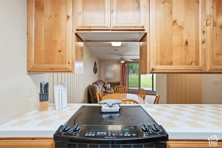 Kitchen featuring a built-in cooktop, light wood cabinetry, and a checkerboard tile countertop