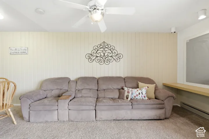 Carpeted room featuring a ceiling fan with integrated lighting, track lighting, and a light wood-finish shelf