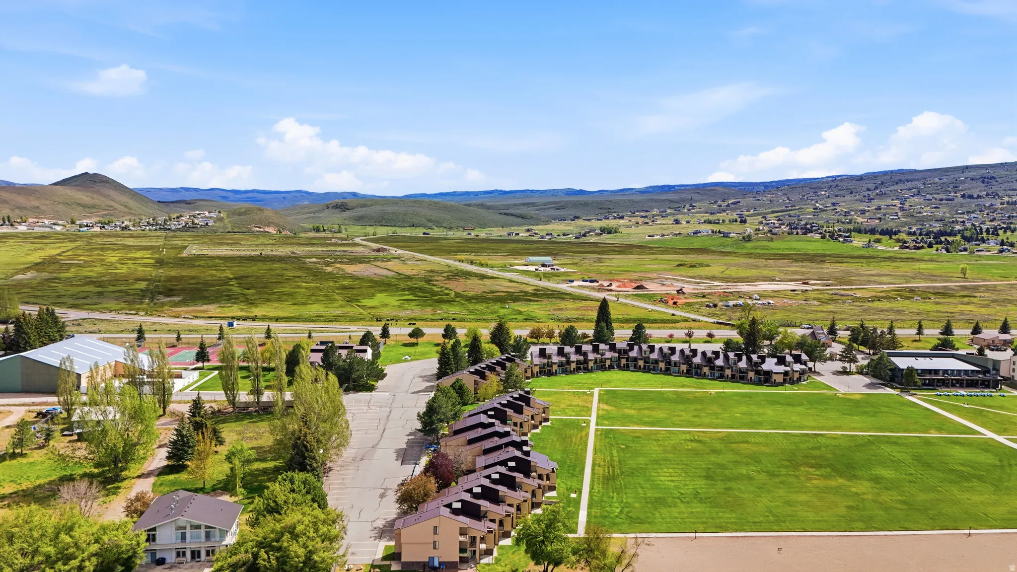 Expansive green fields surrounding multiple residential buildings