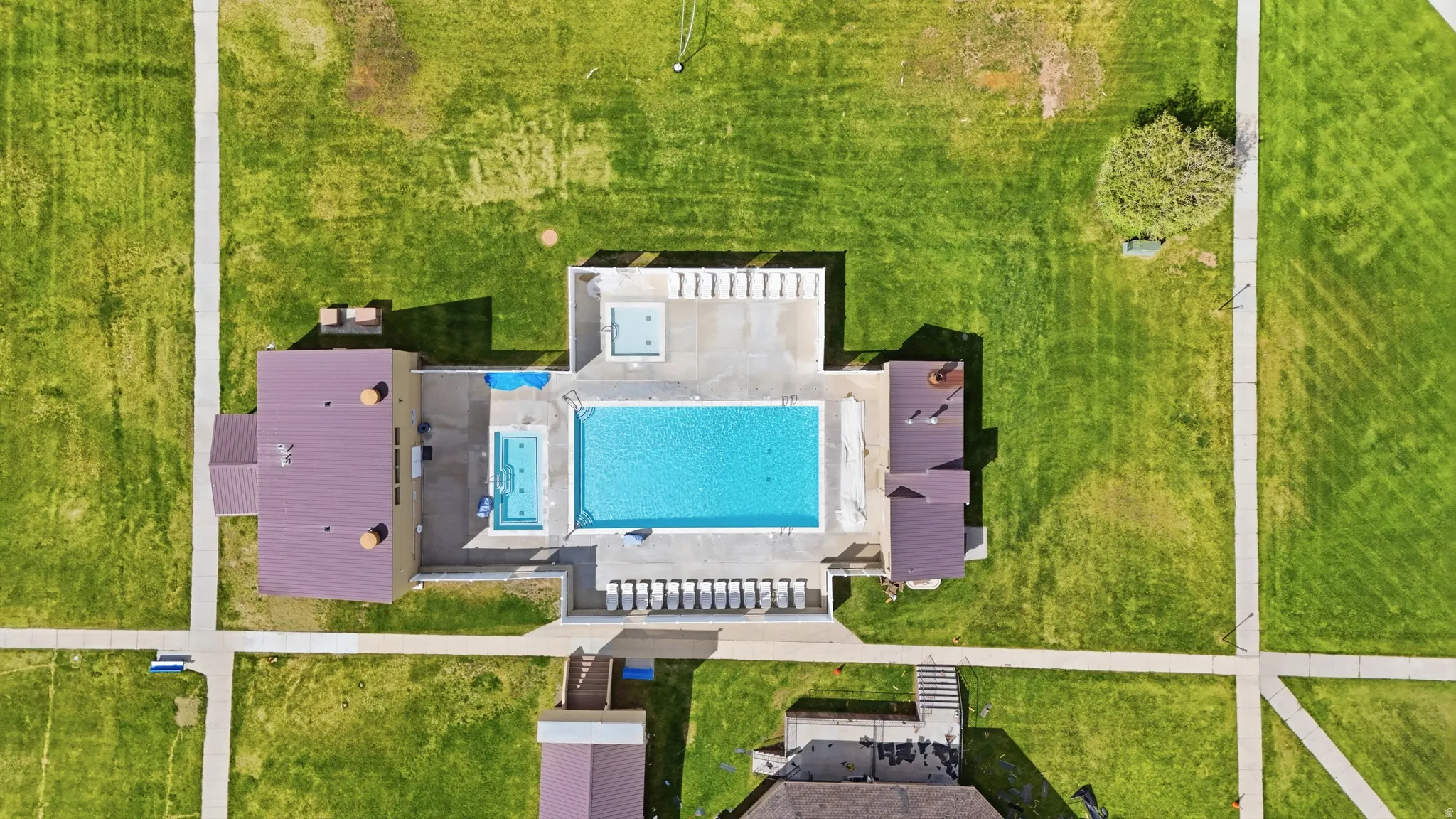 Community recreation area featuring a large swimming pool, a smaller wading pool, and an integrated spa