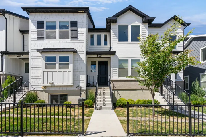 Modern townhome exterior featuring white siding and dark trim accents