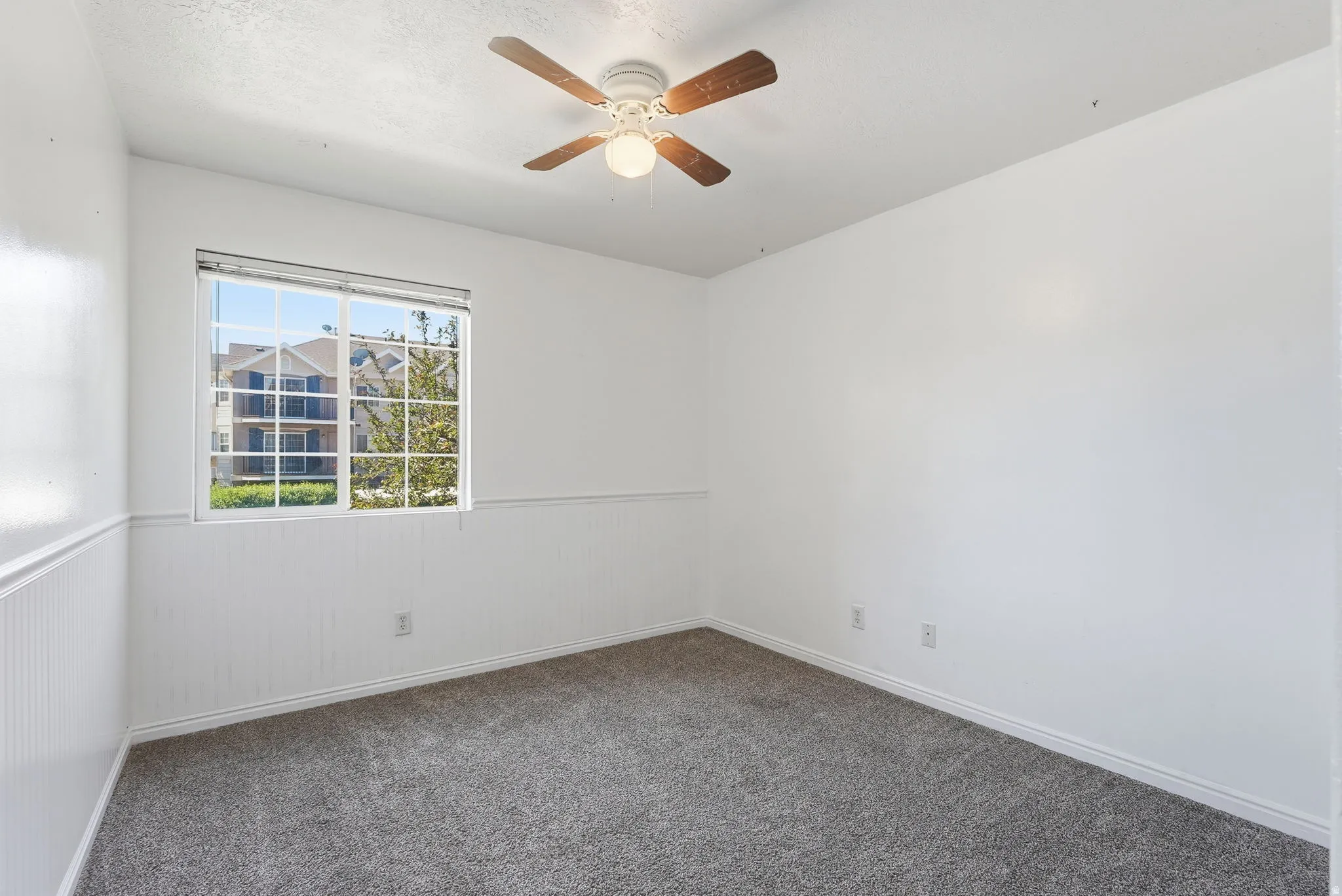 Bedroom 2 featuring a ceiling fan with  white wainscoting
