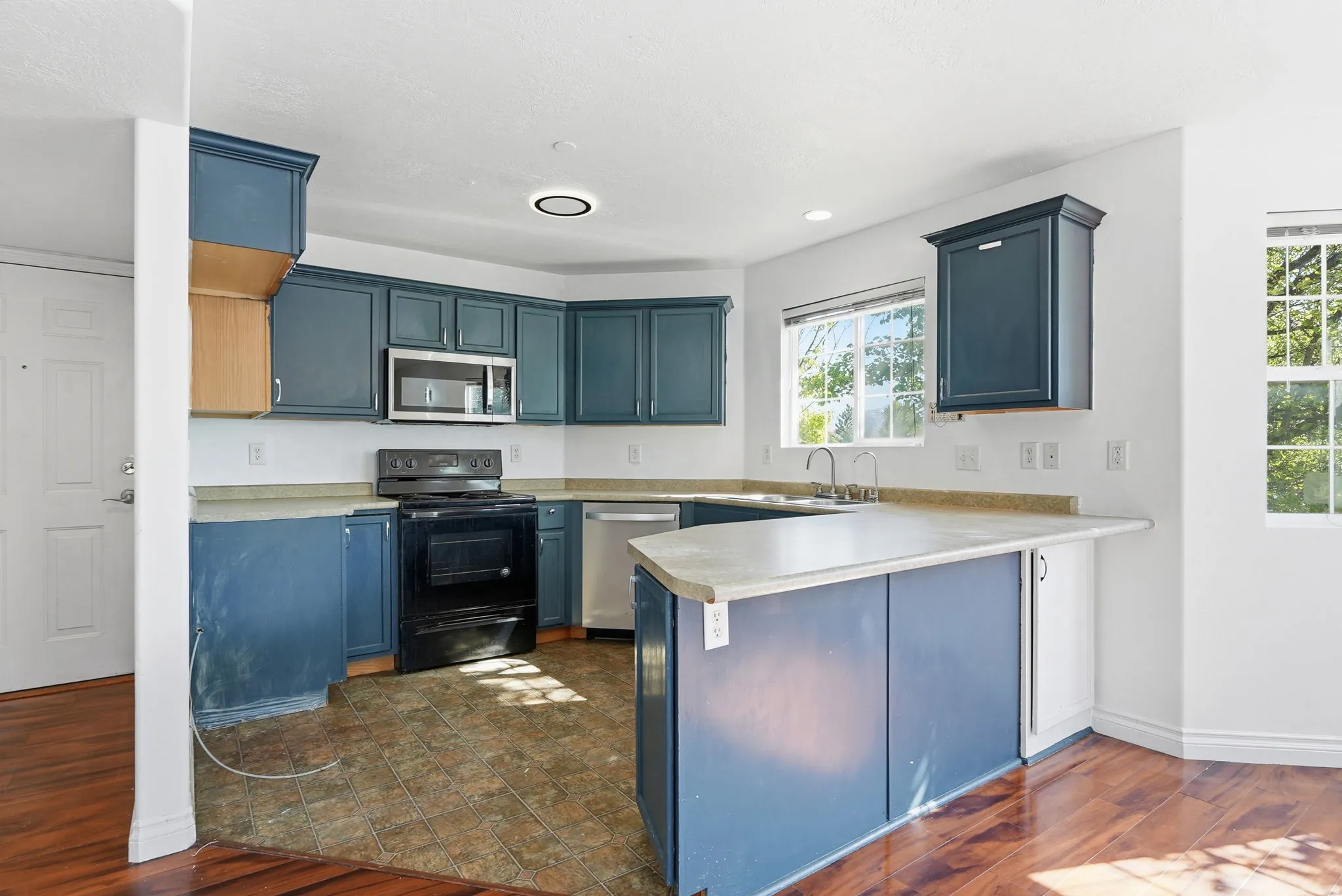Kitchen featuring a corner sink, blue cabinetry, and stainless steel appliances
