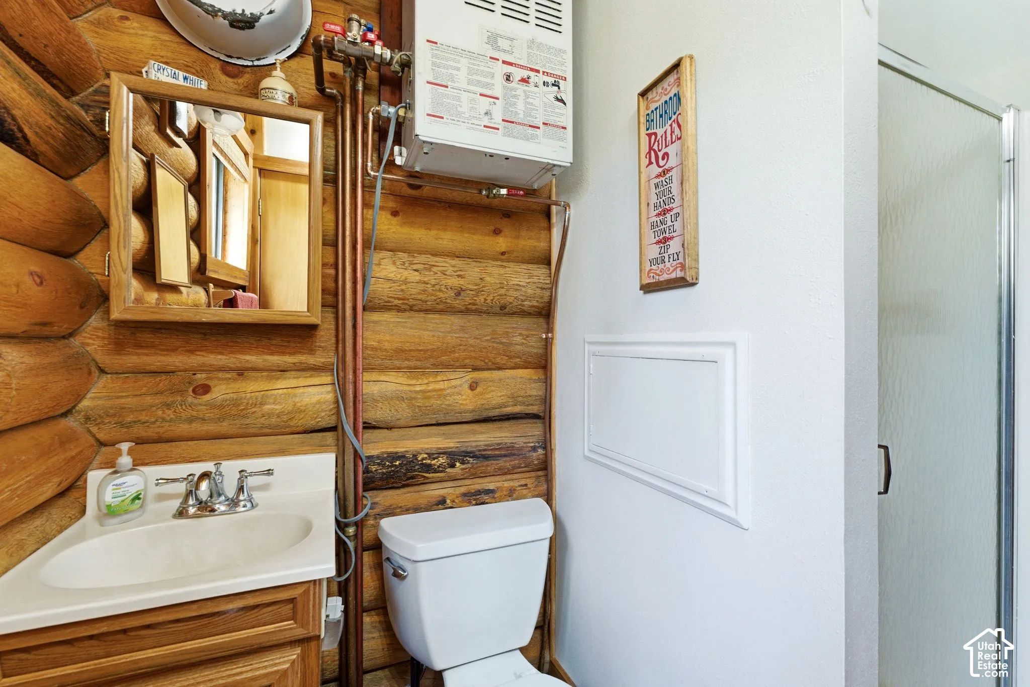 Rustic bathroom featuring log wall construction