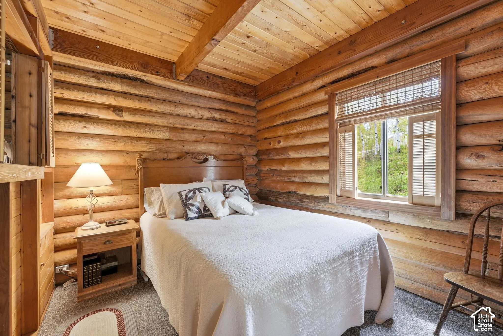 Log cabin interior featuring natural wood walls and ceiling with exposed beams