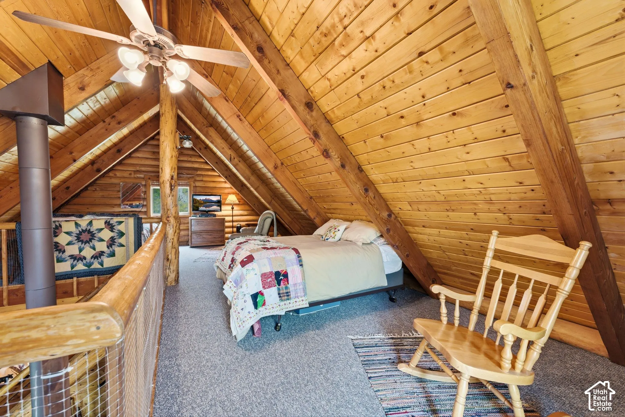 Vaulted ceiling bedroom featuring exposed wood beams and paneling