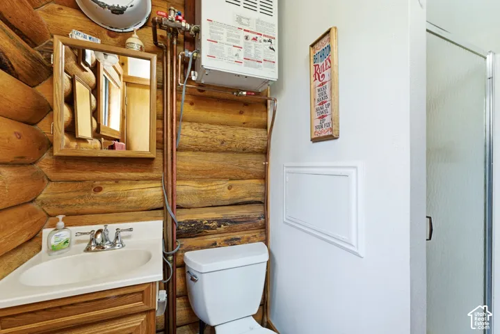 Rustic bathroom featuring log wall construction