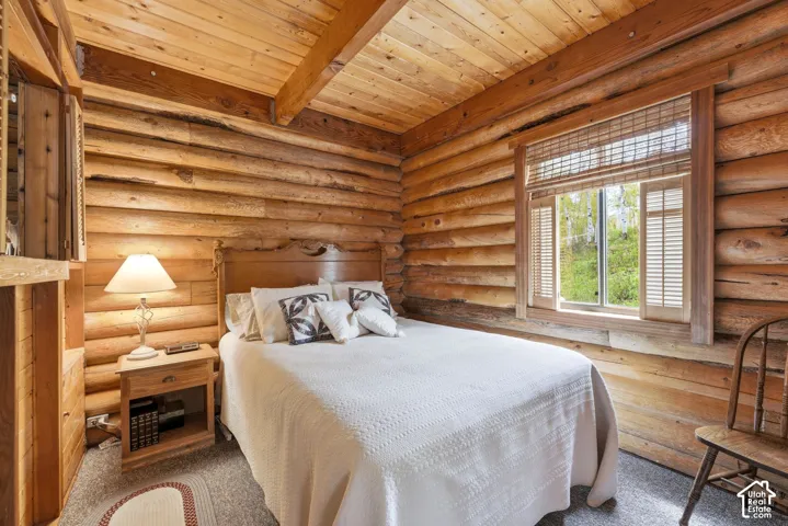 Log cabin interior featuring natural wood walls and ceiling with exposed beams